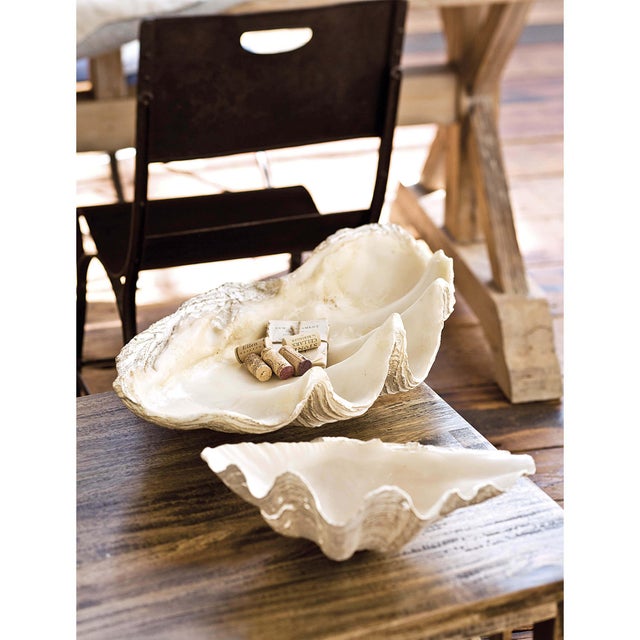 This large clam replica serves as a bowl or decorative object. Its resin construction beautifully mimics the details of a...