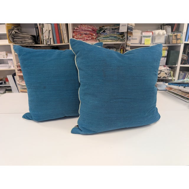 Pair of New Moon 22" square pillows with front featuring a navy blue linen fabric with teal medallions, pale teal piping...