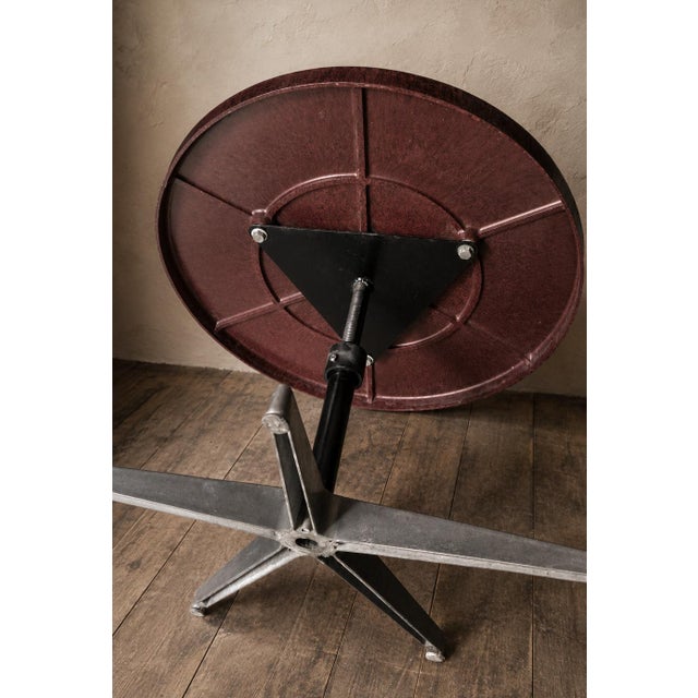 An original vintage coffee table from England, featuring a circular phenolic top, presumably Bakelite, featuring a...