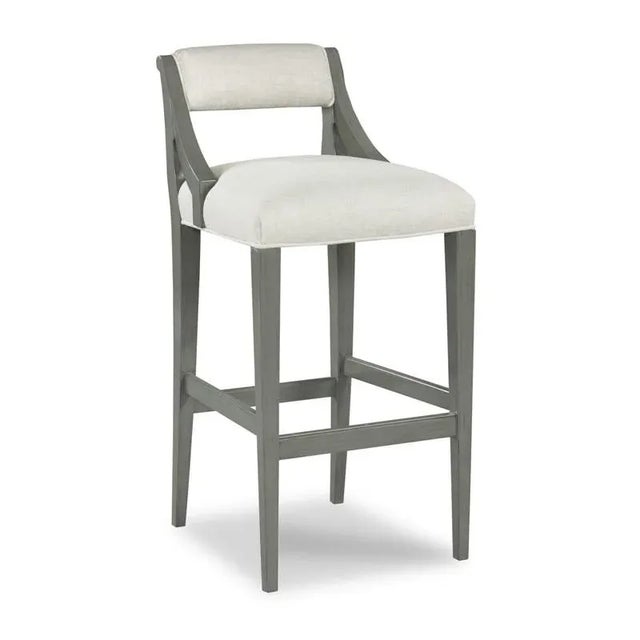 An upholstered back is situated above an upholstered seat with welt trim that is elevated over four squared tapering...