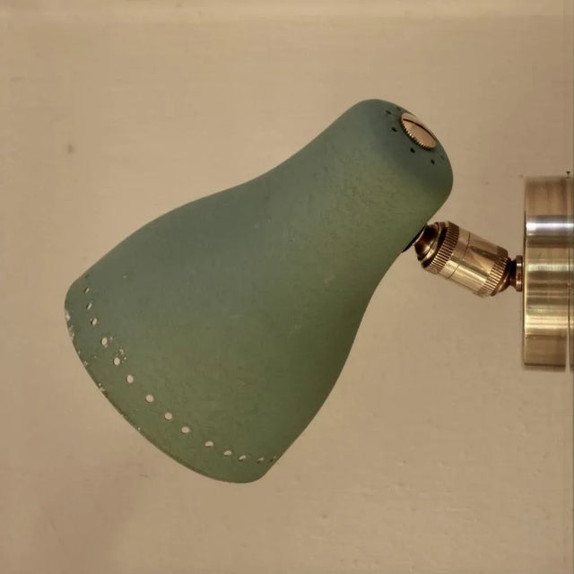 Very rare, unusual wall light consisting of steel and brass. The screen can be variably adjusted by the two ball joints....
