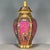 A striking Chinese porcelain vase featuring a vibrant pink ground. The vase has a faceted, hexagonal baluster shape with a...