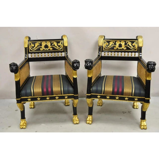 Contemporary Egyptian Revival Regency Style Black Ebonized Gold Gilt Lion Head Cane Lounge Chairs - a Pair. Item features...