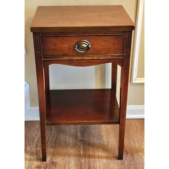 A Mid Century Federal Style Mahogany Tiered Bedside Table. Measures 16" in width, 13" in depth and 27" in height.