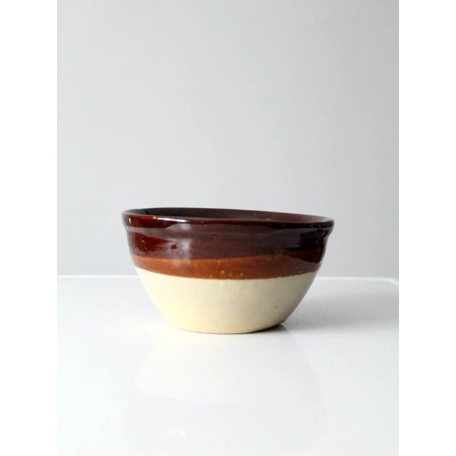 This is an antique stoneware bowl. The bowl features a brown albany slip that fades to light brown. Beautiful heavy bowl...