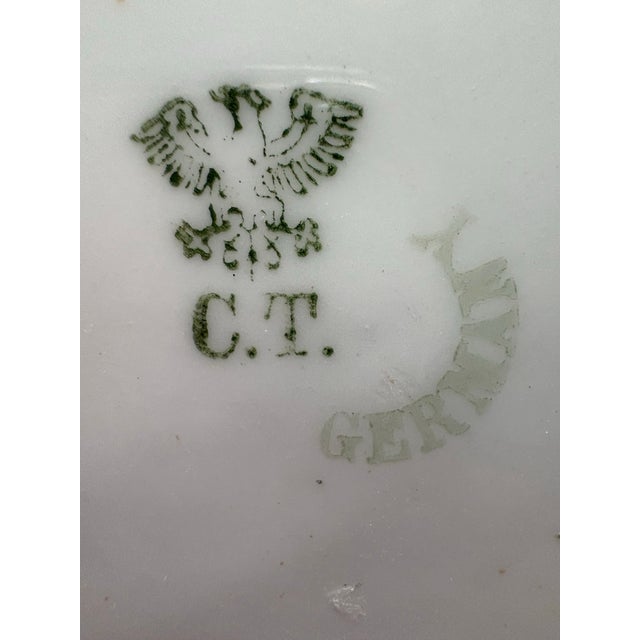 This elegant antique German porcelain plate features finely hand-painted pink floral garlands, delicate ribbon motifs, and...