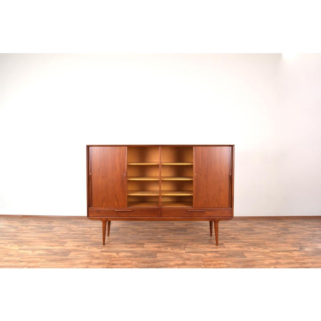 This teak highboard model 13 was designed in the 1960s by Gunni Omann and manufactured by Omann Jun. The furniture has...