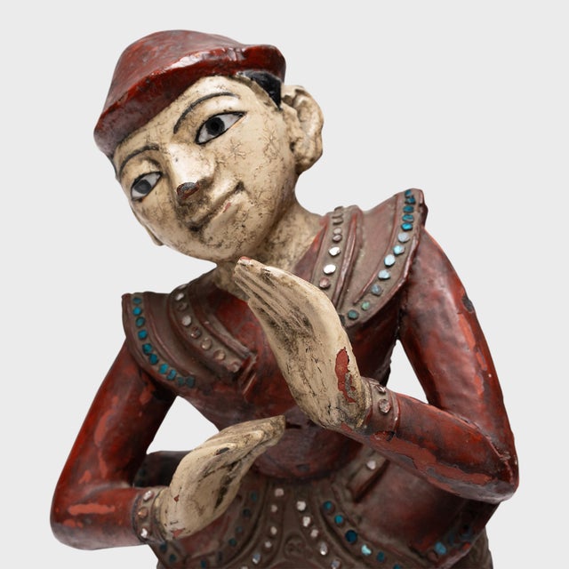 With knees bent and weight shifted to one side, this early 20th century Thai sculpture of a court performer is imbued with...