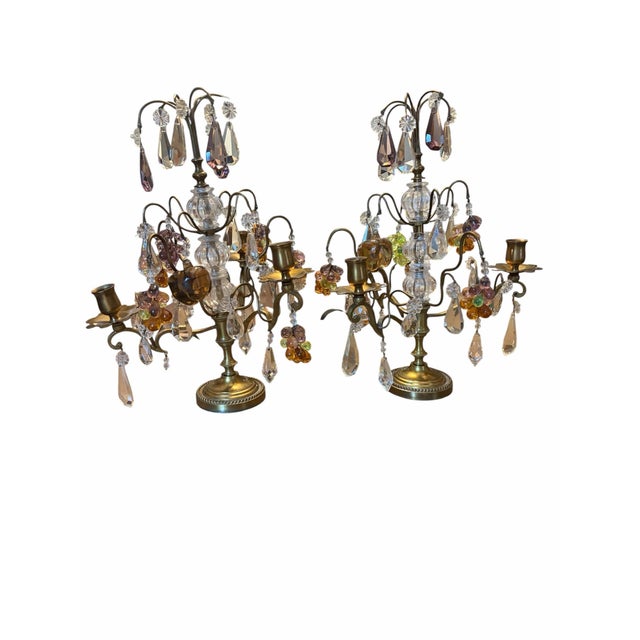 An elegant matched pair vintage French gilt brass candelabra. Adorned with crystal prisms, crystal fruit, glass grape...