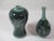 Set of two celadon crackle Korean porcelain vases. They have four decorative panels, hand-painted with various raised...