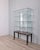 Display cabinet with black metal feet and wheels, brown Formica base and clear glass body with four shelves, designed by...