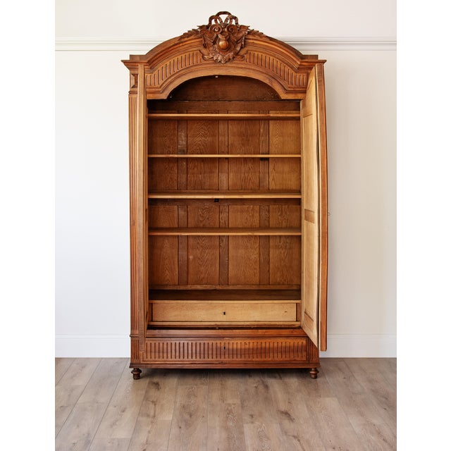 An exceptional antique carved oak armoire of grand architectural form, richly detailed with stately craftsmanship and...