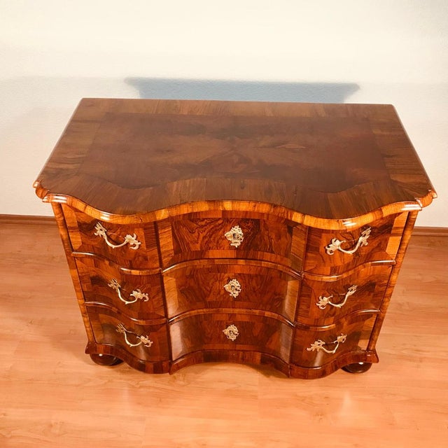 This German Baroque chest of drawers, crafted circa 1750, showcases the bold curves and refined craftsmanship...