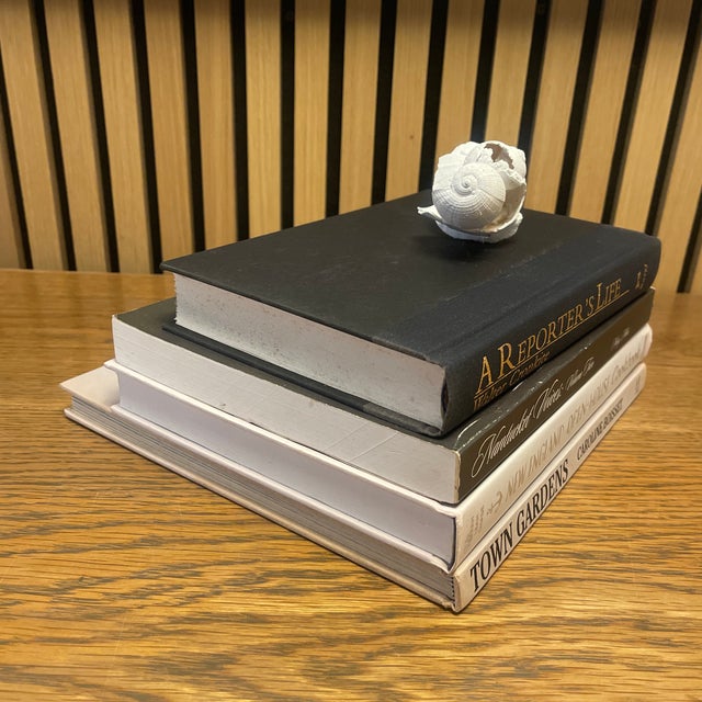 A refined, professionally curated Nantucket-style decorative book stack finished with an original Cheryl Fudge shell...