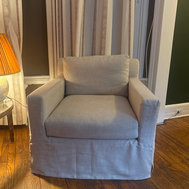 A pair of Restoration Hardware Belgian Slipcovered slope arm lounge chairs in neutral linen. Featuring RH’s signature...
