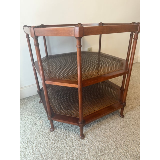Beautiful Baker furniture three-tier octagonal walnut and cane side table. The tables defining element is the bookmarked...