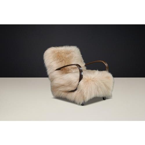 A rare and sculptural 1940s halabala lounge chair, newly upholstered in premium icelandic sheepskin, combining elegant...