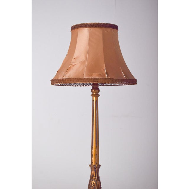 This elegant English floor lamp features a gilded wooden structure, finely crafted with decorative details that embody the...