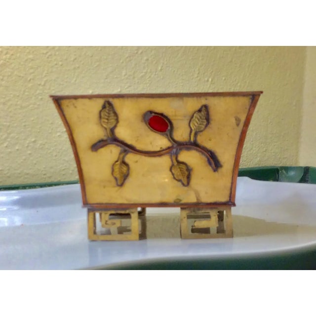 Pair of vintage brass and stone cachepots on oriental base. Raised brass floral and stone on each side.