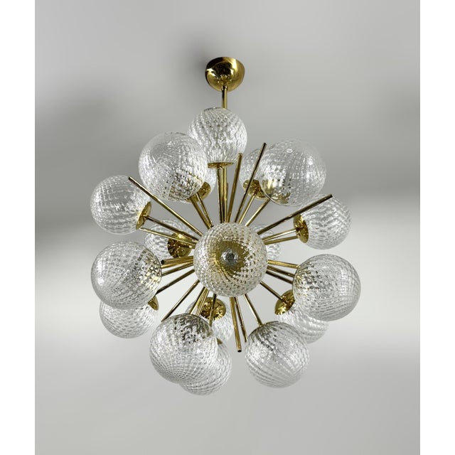 Italian sputnik chandelier with 18 textured balloton Murano glass globes mounted on brass frame in lacquered polished...