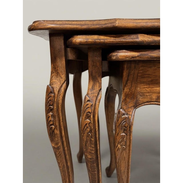 Rad set of three antique French nesting tables. These solid oak beauties, feature iconic, curvy cabriole legs and carved...
