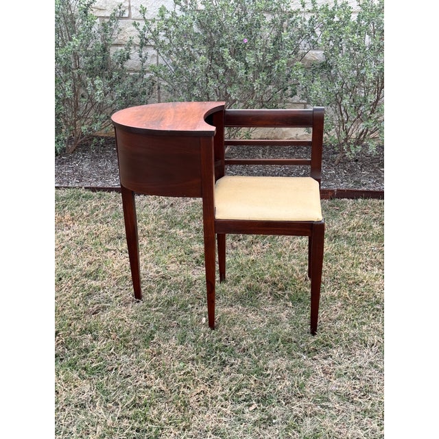 Vintage mid-century gossip bench, also known as a telephone table, which features an integrated chair and side table that...