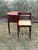 Vintage mid-century gossip bench, also known as a telephone table, which features an integrated chair and side table that...