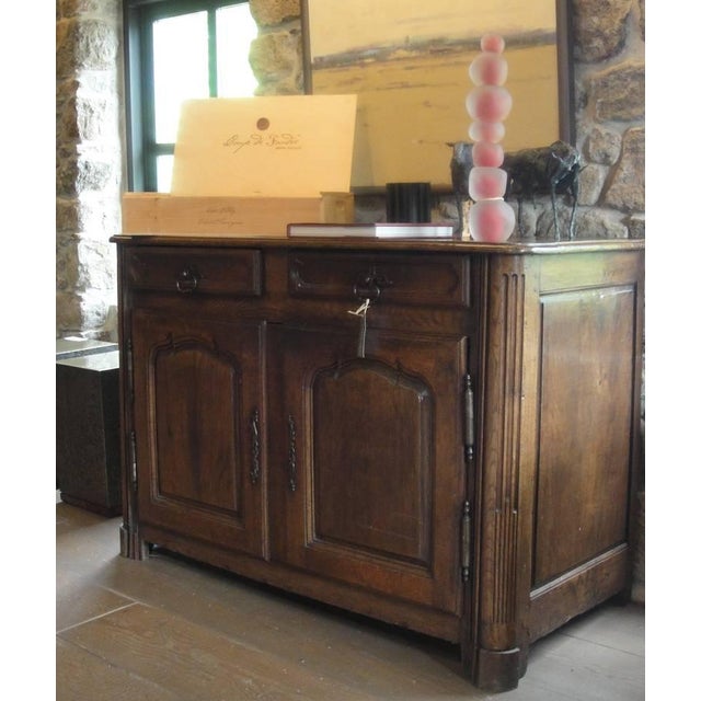 Vintage late 17th century oak buffet with hand-forged metal hardware. Two drawers and two doors, with carved detailing.