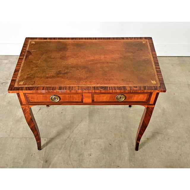 A lovely, petite desk from 19th Century France made of luxurious mahogany and a leather writing surface with gold tooling....
