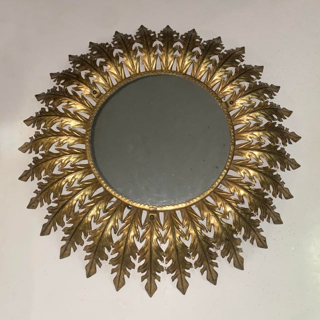 Italian vintage sunburst mirror with backlight. Gold leafed embossed tole rays adorning a circular central mirror. The...