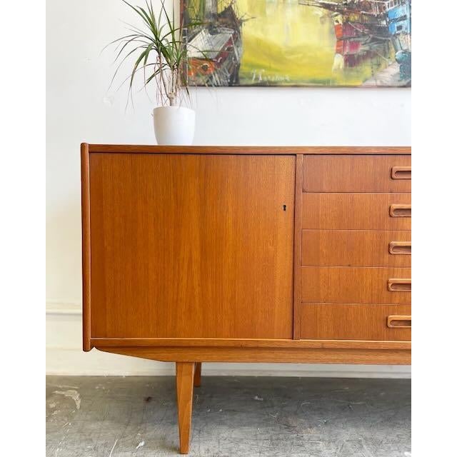 Now available! Beautifully crafted in the late 1950s, this teak sideboard embodies clean lines and timeless design. It...
