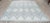This hand knotted pile rug is crafted from wool and presents a neutral color palette featuring ivory, beige, cream, and...