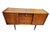 Lovely English mid century modern tola wood sideboard in excellent condition. Three central drawers flanked by cabinet to...
