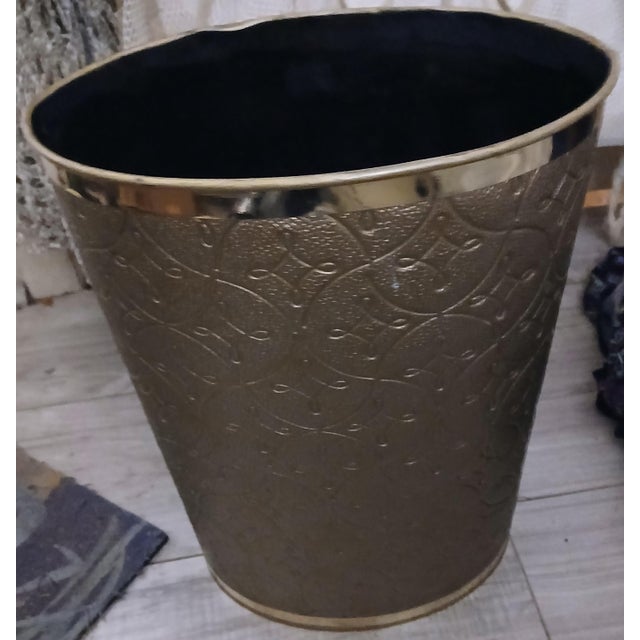 Vintage wastebasket featuring a quilted vinyl texture and brass plated trim. Oval shape with a textured vinyl quilted...