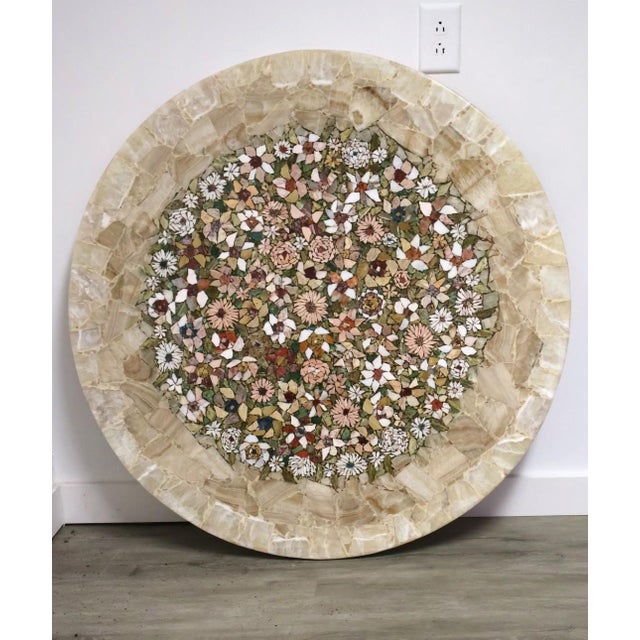 Exceptional circa 1970s round coffee table, attributed to Brazil, featuring a hand-worked polychrome stone floral mosaic...