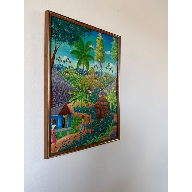 Vibrant vintage Haitian oil painting featuring a lively tropical village landscape, signed “Michelet.” Executed in a...