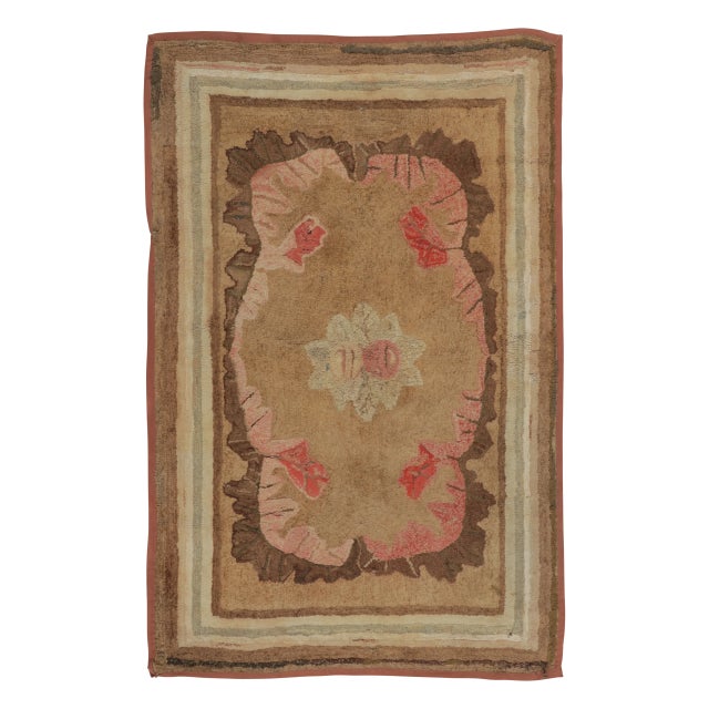 This antique 3x5 hooked rug, circa 1920–1929, features a restrained floral medallion visual juxtaposition in warm earth...