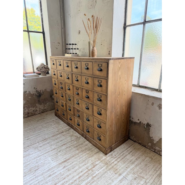 Antique and large 1950s workshop cabinet with numerous drawers. comprising 36 drawers topped with blackened metal shell...