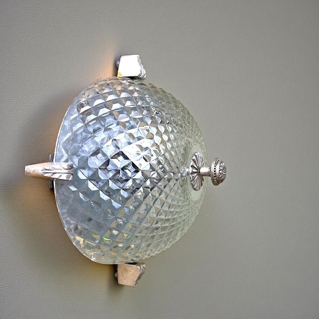 This light can be used as a wall or ceiling light. It is made of clear glass and equipped with a brass base. It works with...