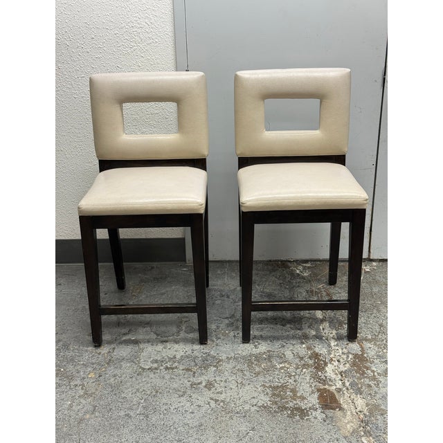 Design Plus Gallery presents a Pair of Bespoke Leather Counter Height Stools. The stools have cream leather upholstery...