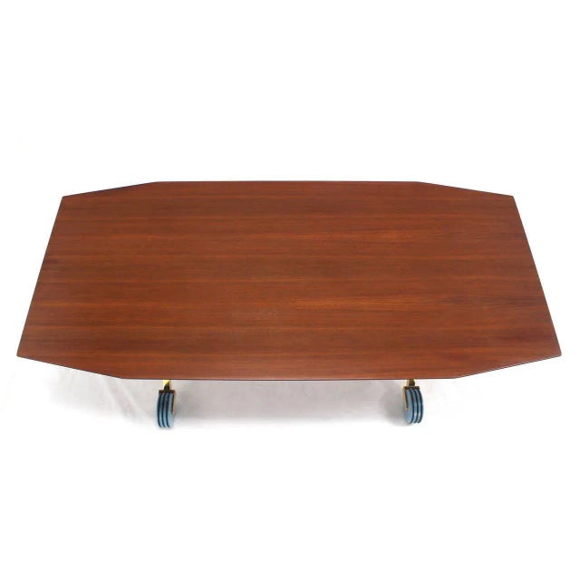 Unusual solid brass base dining table on wheels. Made in the early 20th century.