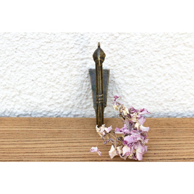 A robust utilitarian antiquity featuring a detailed geometric stem and a stylized architectural bud finial, carrying a...