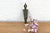 A robust utilitarian antiquity featuring a detailed geometric stem and a stylized architectural bud finial, carrying a...