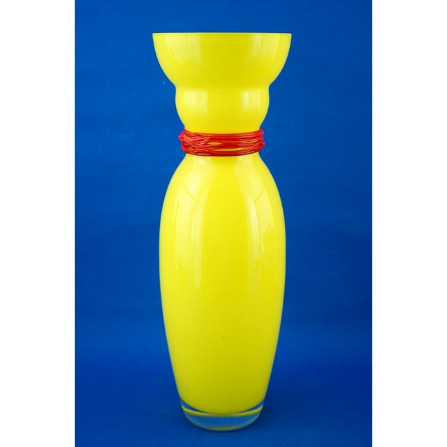 large yellow glass vase, with a red glass paste cord wrapped around the neck, applied by hand while hot, made in...