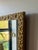 Early 20th-century giltwood wall mirror featuring an embossed floral motif and richly textured gold finish. A beautiful...