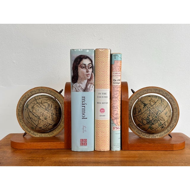 Pair of Italian style wooden bookends with rotating globes featuring antique style maps. The color of the globe pair is...