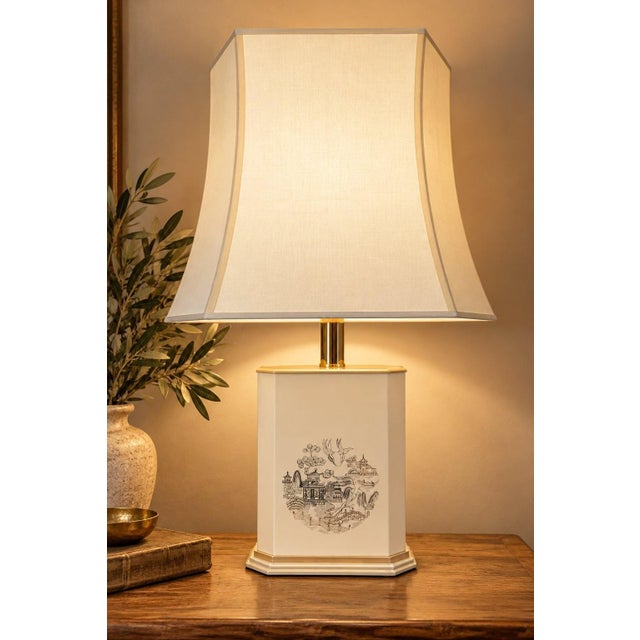 A chinoiserie-style table lamp, likely dating from the 1970s. The rectangular, chamfered base is made of beige composite...