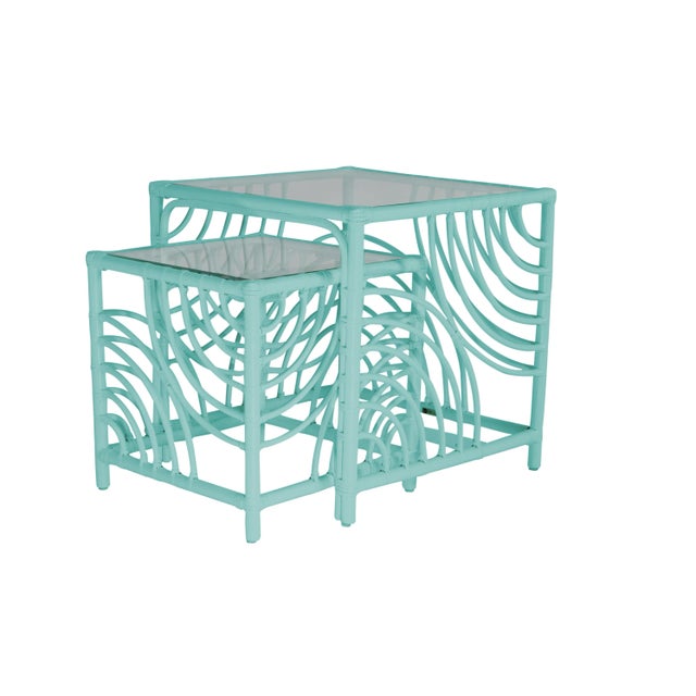 This functional and stylish two-piece nesting table features a Rattan frame with rawhide bindings and a clear, glass top....