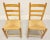 A pair of Cottage style dining side chairs, unbranded. Solid oak with ladder back design, rush seats, tapered round legs...