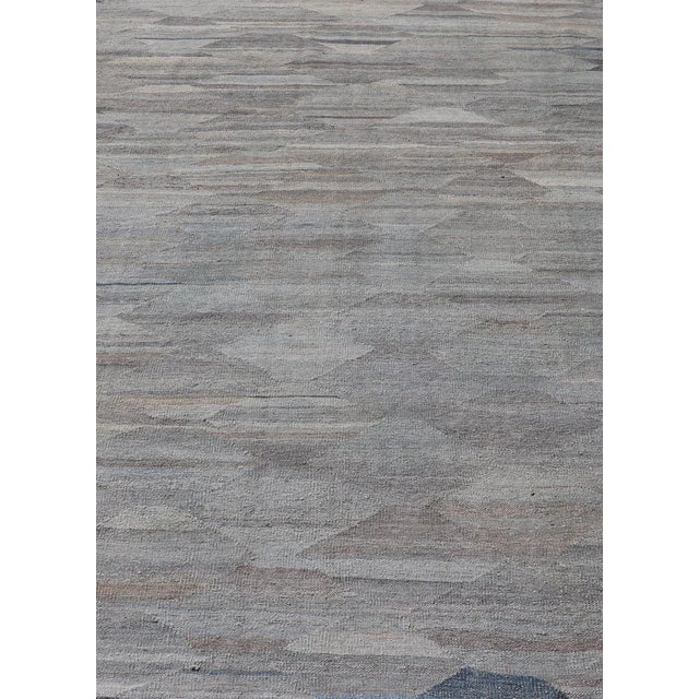 This modern casual tribal kilim has been hand- woven. The rug features a modern sub-geometric diamond design, rendered in...